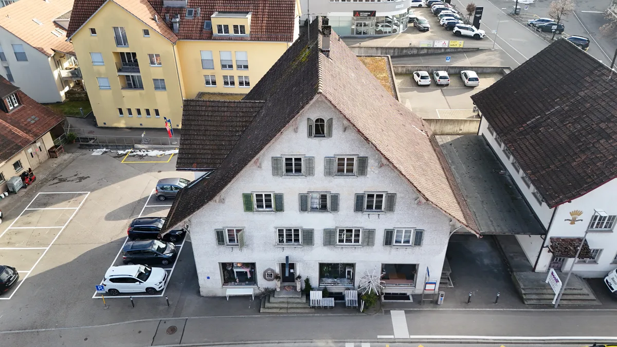 Die Parkplatzflächen links neben dem Landihaus und hinter der Liegenschaft an der Usterstrasse 25 (rechts) sollen im Besitz der Stadt bleiben. (Archiv) Luftaufnahme des Landihauses in Illnau.